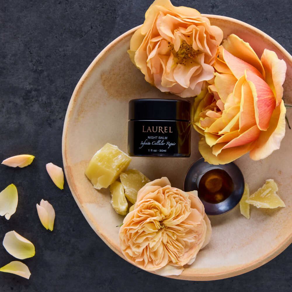 Night Balm surrounded with lush roses and rosehip seed oil