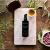 Ca Body Oil and The Lymphatic Body Brush with petals and pine branches